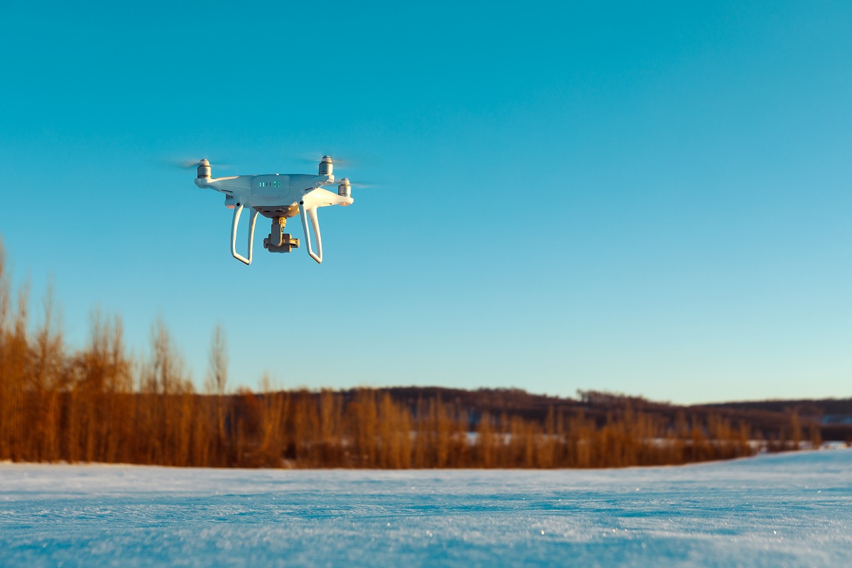 drone flying above field on winter